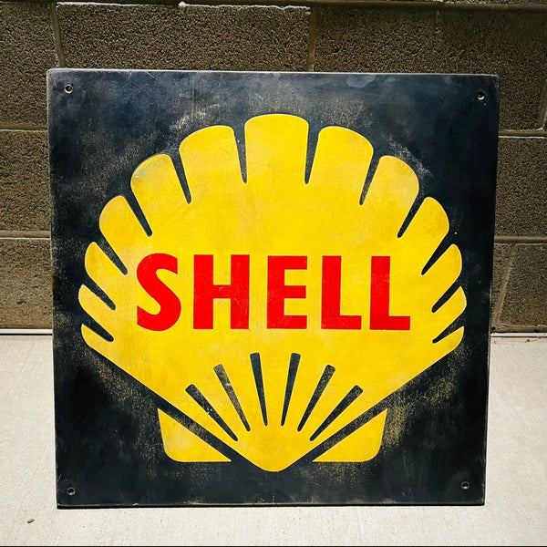 Vintage Shell logo on a wood  sign against a brick wall.